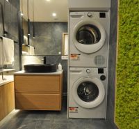 Bathroom in a 3-room apartment with a washing machine, dryer, sink, and a green wall.