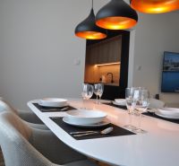 A dining table with lights, set in a 3-room apartment with wood-patterned flooring.