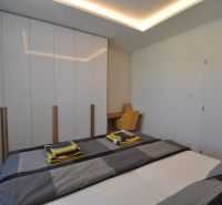 Bedroom in a 3-room apartment with a wardrobe, bed, and wooden decor flooring.