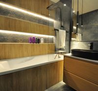 A bathroom in a 3-room apartment with wooden decor and dark tiles.