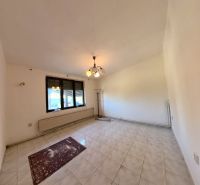 Living room in a family house with tiles and windows.