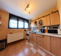 A kitchen with brown cabinets and a spacious window in a family house.