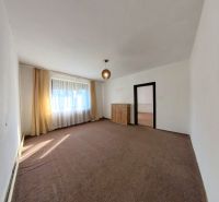 Living room in a family house with carpeted floor, curtains, and light.