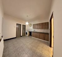 A kitchen in a family house with a floor and wooden kitchen cabinets.