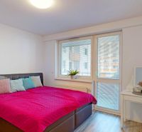 Bedroom with a large bed, nightstand, and mirrored dressing table in a 3-room apartment.