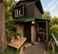 Black cottage in Žilina with greenery and rustic details in the exterior.