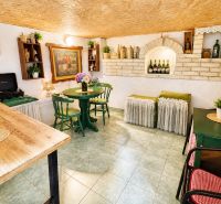 Corner in a chat with a rustic table, green chairs, and decorations.