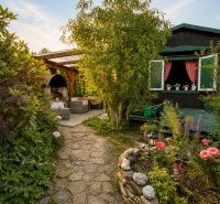 A garden by the cottage in Žilina with stone paths and a flower bed.