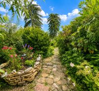 A garden by the cottage in Žilina with a stone path and a flower bed.