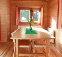 Wooden paneling, table with flowers, floor with wooden decor, and colorful curtains, Cottage.