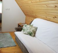 A comfortable sofa with a decorative pillow in a cozy cabin with wooden decorations.