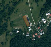 Aerial view of agricultural and forest lands near the village of Oščadnica with visible buildings.