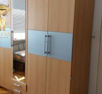A wardrobe with a wooden decor floor in a studio apartment.