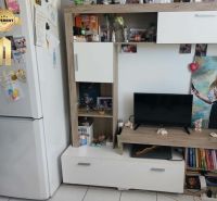 Living room in a studio apartment with white furniture and decorations.