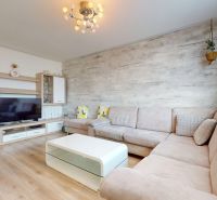 Living room in a 3-room apartment with a sofa, table, and floor with a wooden decor.