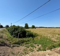 Residential plots in Hokovce, next to the road, with electrical lines above them.