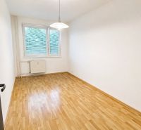 An empty room in a 2-room apartment with a wood-patterned floor and white walls.
