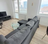 Living room of a 2-room apartment with a sofa, armchair, and TV, floor with wooden decor.