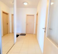 Hallway in a 2-room apartment with a large mirror, tiled floor, and white walls.