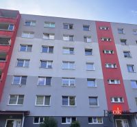 A six-story apartment building in Utekáč with balconies and colored sections of the facade.