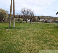 A grassy plot near a family house in Volica with a view of the surrounding countryside.