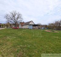 A family house in the village of Volica with a grassy plot and trees in the background.