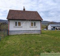 A family house in Volica with a grassy plot and hilly landscape in the background.