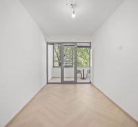 A white room with a glazed balcony and a wooden decor floor in a 4-room apartment.