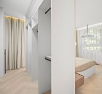 A wardrobe by the bedroom with shelves, curtains, and a wooden decor floor in a 4-room apartment.