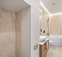 A bathroom with a bathtub and a sink with beige walls in a 4-room apartment.
