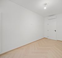 A bright room with white walls and a wooden decor floor.