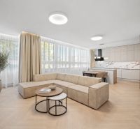 Living room in a 4-room apartment with a wooden decor floor and a corner sofa.