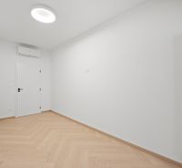 A white room with built-in air conditioning and a wooden decor floor in a 4-room apartment.