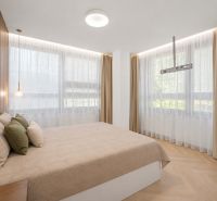 A bright bedroom with a large window, curtains, and a wooden decor floor in a 4-room apartment.