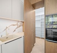 A kitchen in a 4-room apartment with wooden cabinets and a floor with a wood pattern.