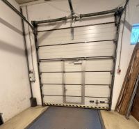 Warehouses and halls with a sectional door and flooring with a wood decor.