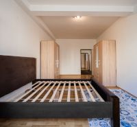 A bedroom in a 2-room apartment with an empty bed and wardrobes.