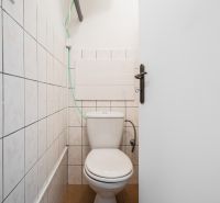 Bathroom in a 2-room apartment with a toilet and a boiler on the wall.