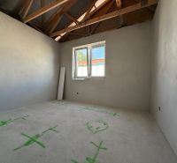 Interior of a family house with an unfinished ceiling structure and drawings on the floor.