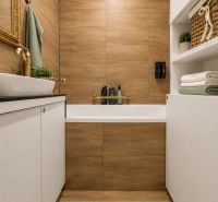 A bathroom with wood-patterned tiles, white cabinets, and accessories in a 3-room apartment.