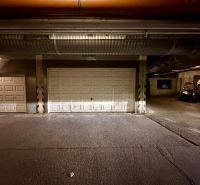 The interior of garages with closed doors and parked vehicles.