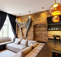 Design interior of a 2-room apartment with a brick wall and a comfortable sofa.