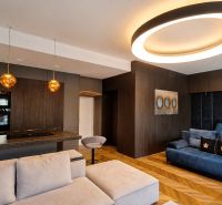Living room in a two-room apartment with a wooden decor floor and interesting lighting.