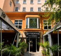 A restaurant on Hviezdoslav Square in Bratislava - Old Town, surrounded by greenery and palm trees.
