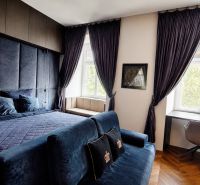 Luxury bedroom with dark curtains and a desk in a 2-room apartment.