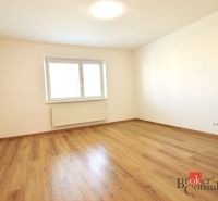 A spacious room with a wooden decor floor in a 2-room apartment.