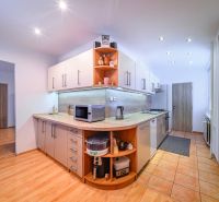 A kitchen in a 2-room apartment with a wooden decor floor and modern appliances.