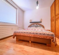 A bedroom with a wardrobe and a wooden decor floor in a 2-room apartment.