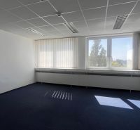 Office with dark carpet, white walls, and a large window.