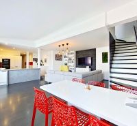 A kitchen in a 3-room apartment with a staircase and a floor with a wooden decor.